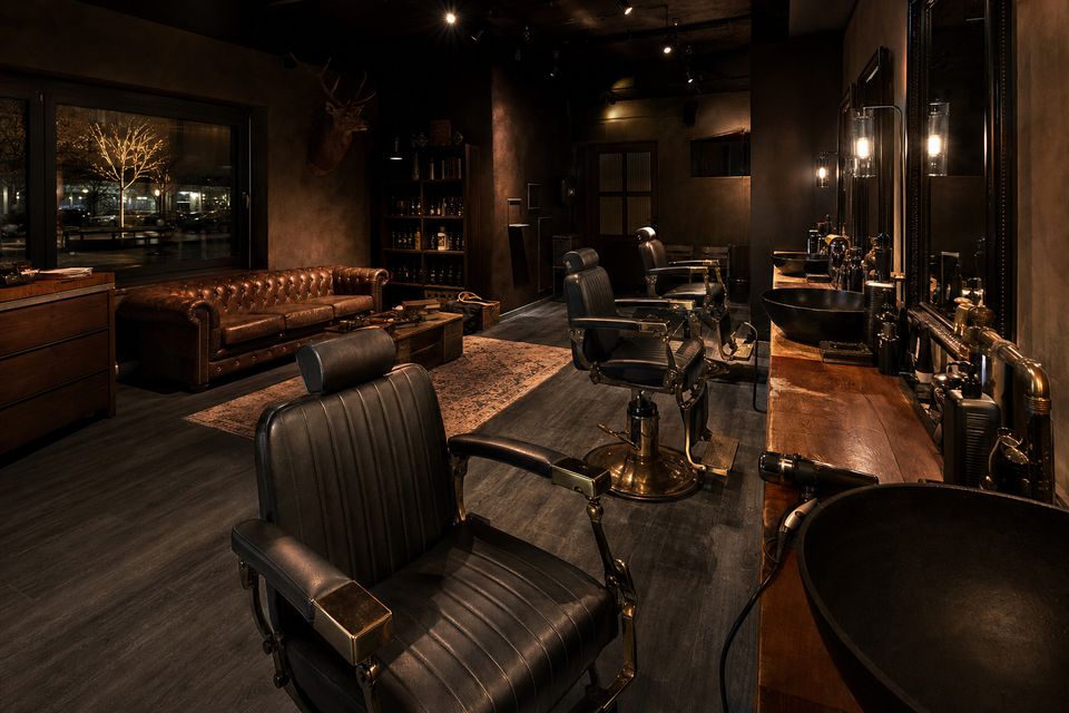 Dunkler Barbershop am Abend, warmes Kunstlicht auf Leder und Messing